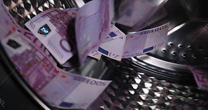 euro 500 paper money banknotes in the washing machine. dirty criminal money laundering and shadow economy concept