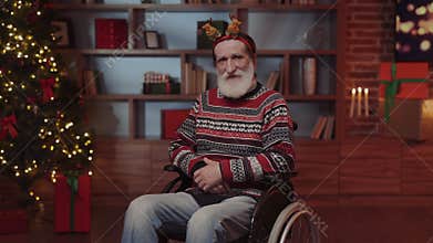 Positive Elderly Man in Festive Mood, Sitting in the Wheelchair in the Decorated for Chistmas House Alone. Disabled