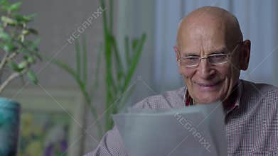 Elderly man reads interesting article and smiles carelessly