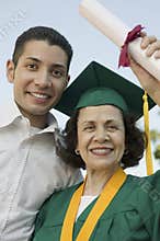 Female Graduate With Her Son Holding Degree