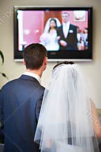 Bride and groom watch the video of his wedding