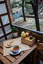 Morning setup on wooden table at balcony for morning relaxation with books, cup of tea, teapot, organic honey, green tea leaves
