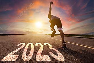 Young man running and sprinting on the road with new year 2023 concept
