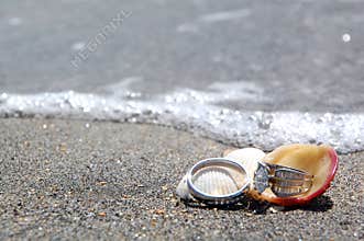 Wedding rings on tropical beach by sea