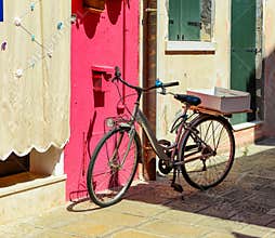 Bicycles parked in front of a colorful house in Burano island, Italy