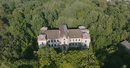 circular flight and aerial panoramic view overlooking the old abandoned palace or historic buildings in forest