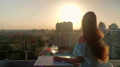 Woman is with a cocktail. Girl from the back with beautiful long hair.