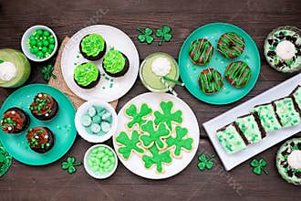 St Patricks Day dessert table scene over dark wood