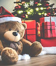 Big teddy bear under Christmas tree with gits