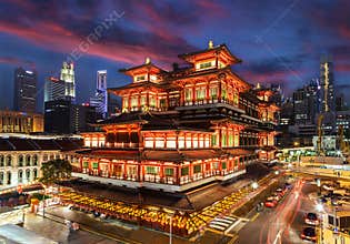 Sunset over Chinatown temple in Singapore decorated for Chinese New Year, with city skyline in background