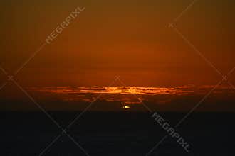 Vibrant Ocean Sunset with Fiery Orange Sky and Clouds
