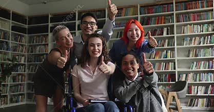 Girl with disability sit in wheelchair pose with groupmates indoors