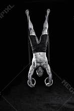 Strong gymnast works on the rings