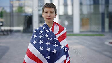 Serious Caucasian Woman Proudly Representing her Home Country and Putting USA Flag on her Back. Stylish American