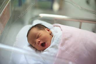 New born infant asleep in the blanket in delivery room