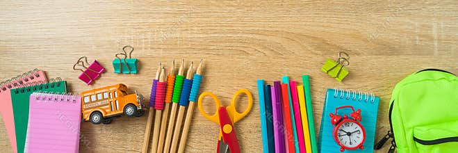 Back to school banner with school supplies on wooden desk background. Top view, flat lay