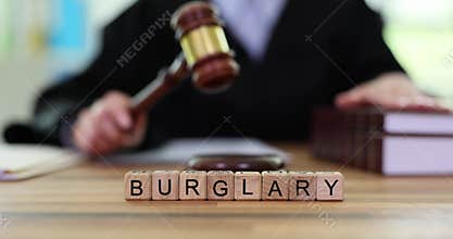 Burglary word of wooden cubes on table against judge