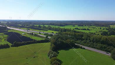 Aerial view on the A7 motorway in northern Germany between fields and meadows