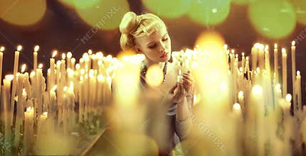 Adorable woman among milions of candles