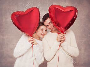 Young couple with balloons in the form of heart