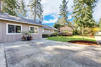 Brown grey house exterior with large driveway.