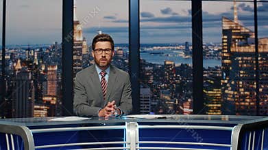Serious anchor reporting events at newsroom. Presenter speaking at news desk