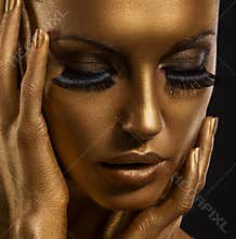 Gilt. Golden Woman's Face Closeup. Futuristic Giled Make-up. Painted Skin