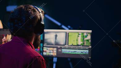 Videographer adjusting clips while listening music in headphones