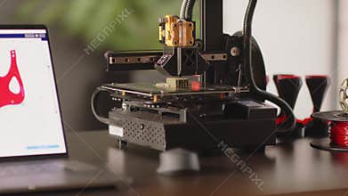 A 3d printer machine creates a model of postoperative fixation bandage in red colour for the heart and chest for women