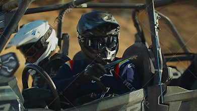 Closeup of two Ranger riders putting on seat belts during UTV Polaris