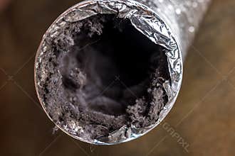 A dirty laundry flexible aluminum dryer vent duct ductwork filled with lint, dust and dirt