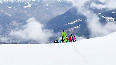 Many skiers on alpine ski resort go down the slope