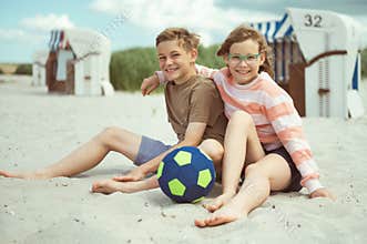 Happy teen children joyful talking on white beach at Baltic sea at summer holidays
