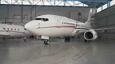 Steady cam shot of a New Airplane Standing in a Aircraft Maintenance Hangar