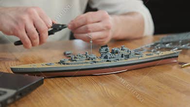 Man assembler model of toy and screws elements with tool