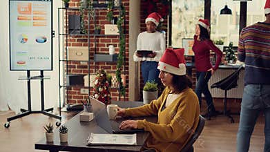 Office worker sending email on laptop during christmas holiday