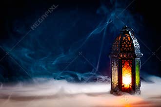 Ramadan Kareem greeting card design. Arabic Lantern glowing at night on table with smoke. Eid Mubarak, Muslim Holy Month concept