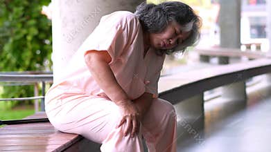 Senior woman having painful expression from a serious leg and knee pain having difficulty. Old woman walking and hurt at knee from