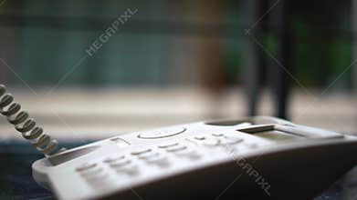 Man hand picking up the landline phone to answer a call retro telephone