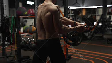 back view of athletic man in sport gym do landmine exercise. athletic man with barbell landmine