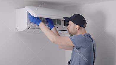 Handyman does routine air conditioning maintenance in the apartments. Hand work