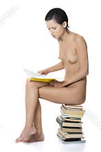 Naked nude woman sitting on pile of books