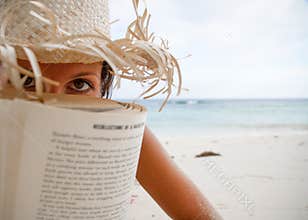Woman reads a book on beach