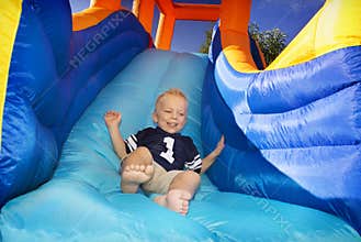 Boy sliding down an inflatable Slide