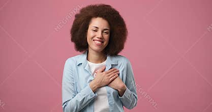 Young pretty smiling african american woman putting hands on chest expressing sincere gratitude, warm appreciation