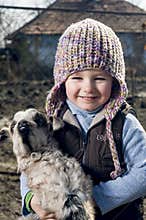 Girl embracing a goatling.