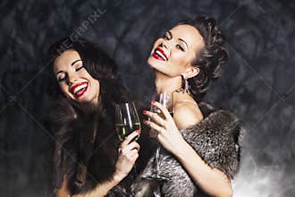 Rich women laughing with crystal of champagne