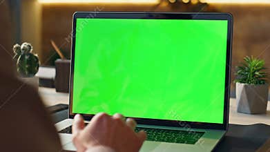 Worker scrolling touchpad green screen laptop at office workplace close up.