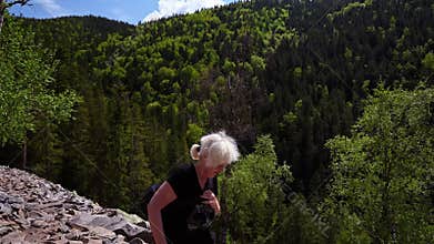 A hiker crosses a rock-strewn trail.