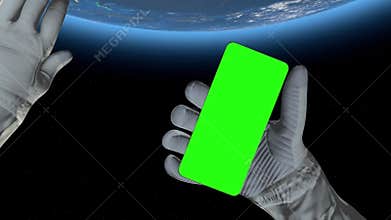 Astronaut in outer space holds a smartphone with green screen, ideal for advertising, branding, or promotional content in sci-fi